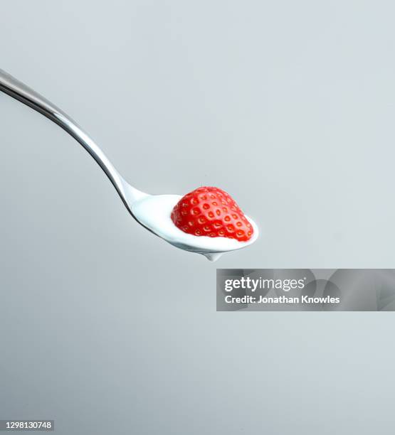 strawberry and yogurt on spoon - strawberries and cream stock pictures, royalty-free photos & images