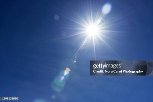 sunburst with lens flare - calor fotografías e imágenes de stock