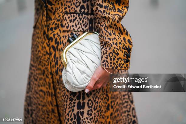 Natalia Verza aka Mascarada wears a total Miu Miu look made of a brown leopard print long trench coat with black lapels, a white leather quilted Miu...