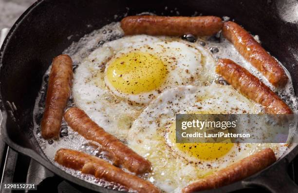 frying eggs and breakfast sausages - breakfast sausage stock pictures, royalty-free photos & images