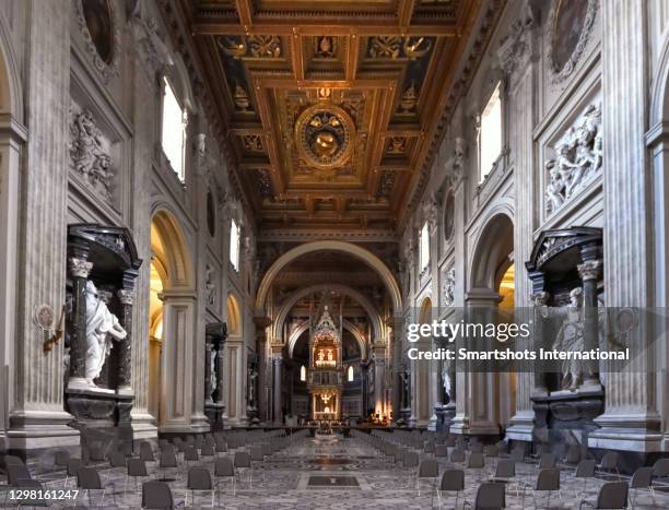 nave, statues, altar and gothic "ciborium" ("baldaquin") with the relics of st peter and st paul in "st john lateran" basilica in rome, italy - expensive statue stock-fotos und bilder