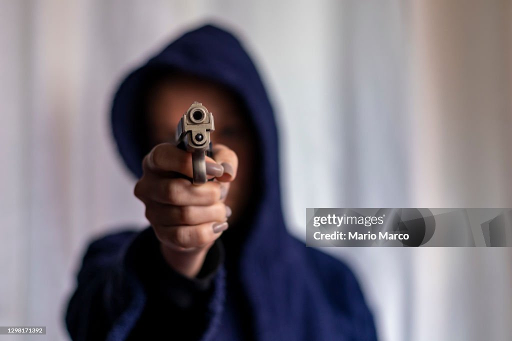 Armed woman with hood