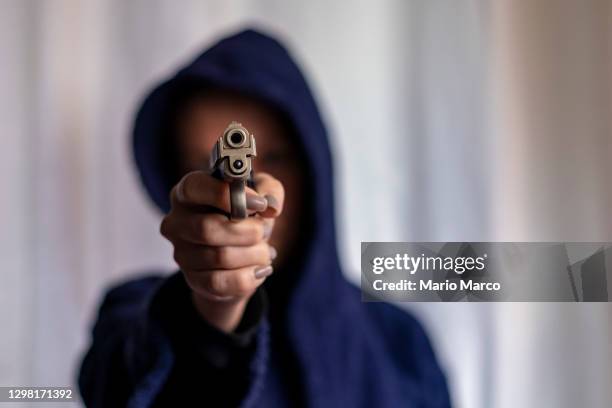 armed woman with hood - schieten stockfoto's en -beelden