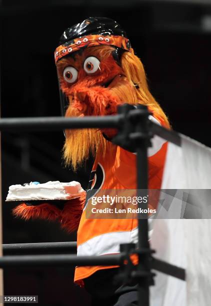 Gritty the mascot of the Philadelphia Flyers readies to throw a cake during a stoppage in play at an NHL against the Buffalo Sabres at the Wells...