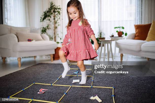 active cute smiling  toddler girl having fun jumping, playing hopscotch at home - hopscotch stock pictures, royalty-free photos & images