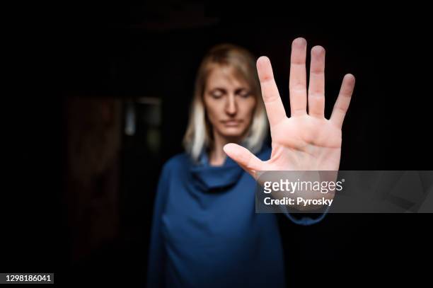 giovane donna che mostra il segno stop con il palmo della mano - anti bullying symbols foto e immagini stock