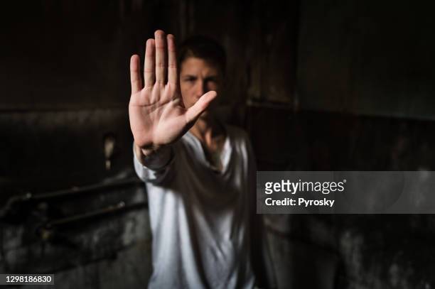 junger mann zeigt stop-zeichen mit seiner handfläche - victim stock-fotos und bilder