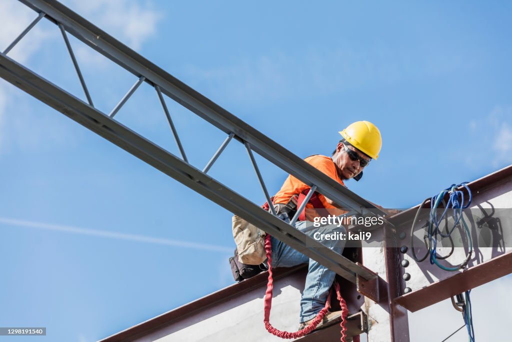 Ironworker em canteiro de obras instalando joist telhado
