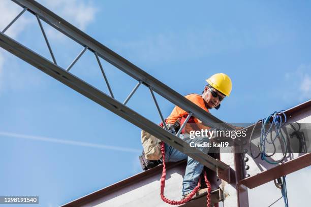 ironworker at construction site installing roof joist - operário siderúrgico imagens e fotografias de stock