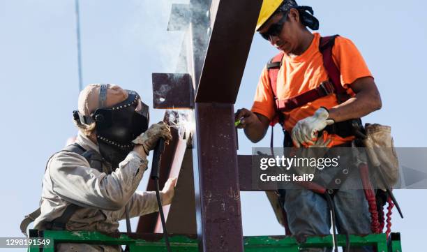 ironworkers at construction site installing girder - steel worker stock pictures, royalty-free photos & images