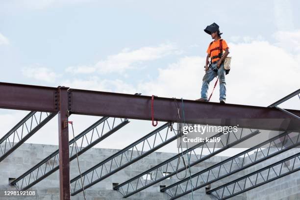trabajador de hierro en el sitio de construcción instalando vigas de techo - viga característica arquitectónica fotografías e imágenes de stock