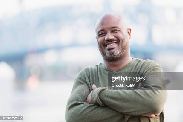 uomo afro-americano maturo in piedi sul lungomare della città - chubby foto e immagini stock