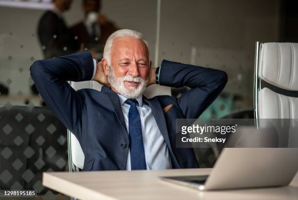 l'uomo anziano si rilassa nel suo ufficio. - chief administration office foto e immagini stock