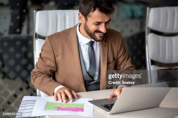 young man using laptop, having project plans in front of him. - person in front of computer stock pictures, royalty-free photos & images