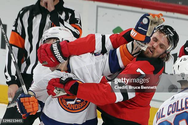 Casey Cizikas of the New York Islanders and Matt Tennyson of the New Jersey Devils get the gloves up during the third period at the Prudential Center...