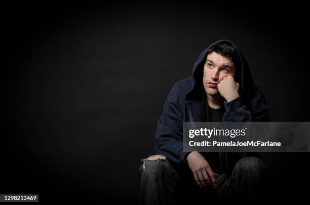 porträt eines depressiven jungen mannes, der nach oben schaut - winterdepression stock-fotos und bilder
