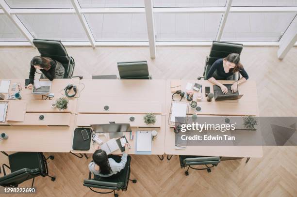 directamente por encima de las mujeres hermosas chinas asiáticas con máscara protectora trabajando en la oficina de plan abierto observando con el nuevo sop y las precauciones de seguridad de prevención de enfermedades de distanciamiento social - coworking fotografías e imágenes de stock