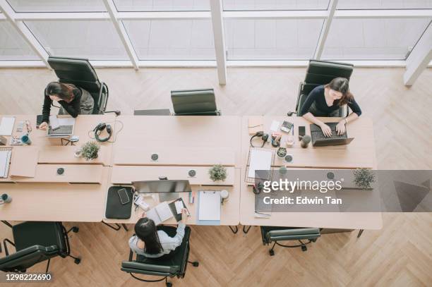 directly above asian chinese beautiful women with protective facemask working in open plan office observing with new sop and social distancing illness prevention safety precautions - place of work stock pictures, royalty-free photos & images