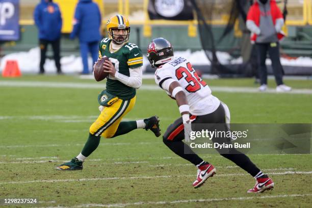 Aaron Rodgers of the Green Bay Packers drops back to pass while being chased by Mike Edwards of the Tampa Bay Buccaneers in the third quarter during...