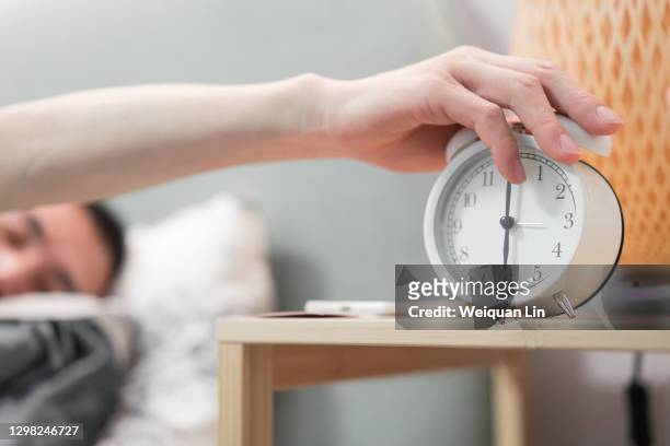 man is holding alarm clock - 目覚まし時計 ストックフォトと画像