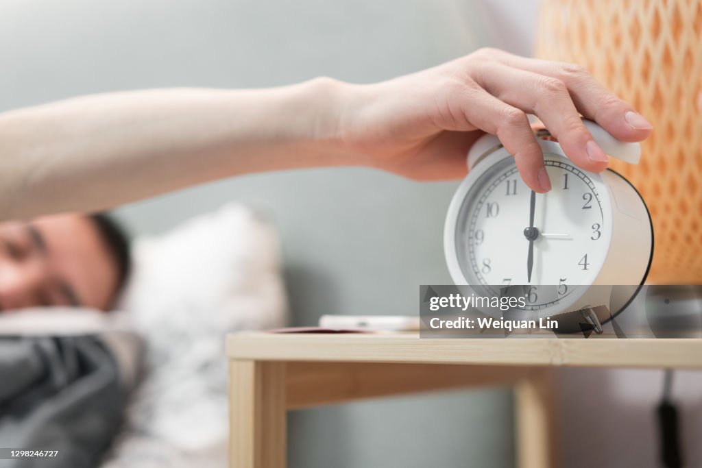 Man is holding alarm clock