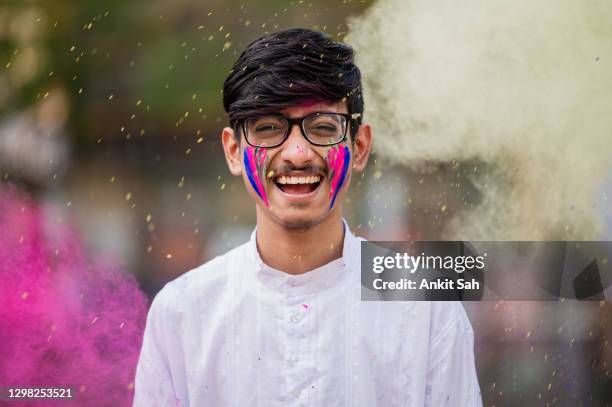 young boy plays with holi festival colours - holi portraits stock pictures, royalty-free photos & images