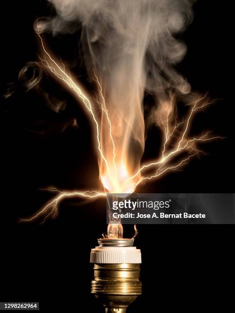 burning light bulb filament with an electric explosion with flash of lightning on a black background. - broken lamp stock-fotos und bilder