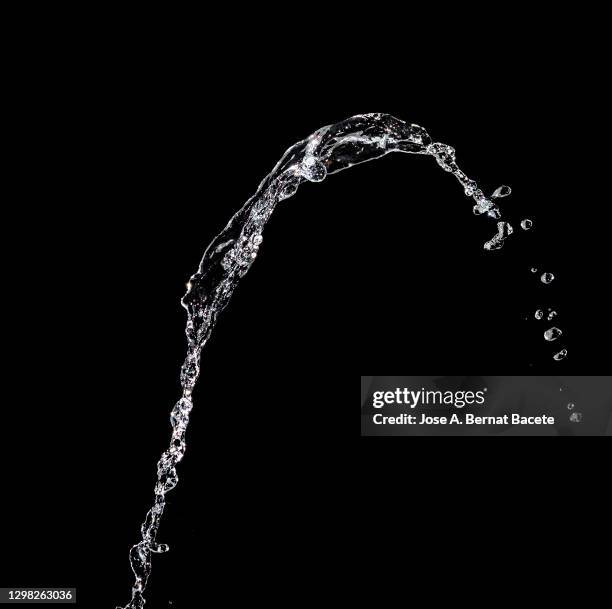 splashes, jet and drops of water in motion suspended in the air on a black background. - fallande vatten bildbanksfoton och bilder