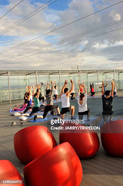 Cours de yoga sur la terrasse panoramique de la Tour Montparnasse, 30 juillet 2018, Paris , France.