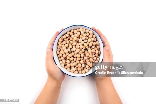 child's hands holding raw chickpeas in the bowl. - kid hand raised stock pictures, royalty-free photos & images