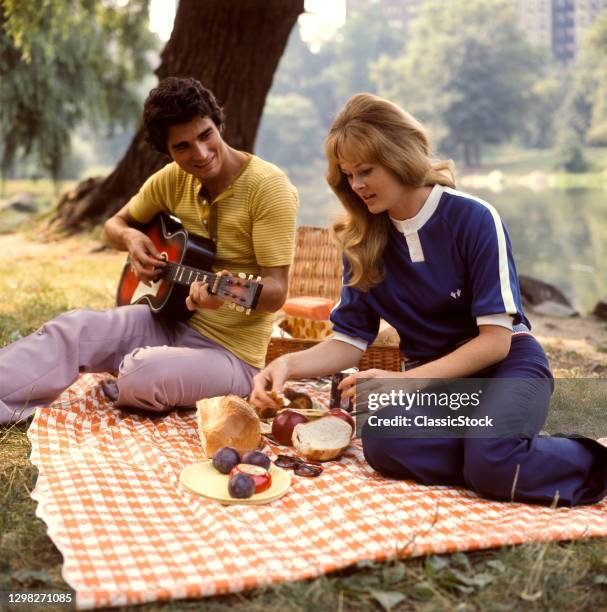 1970s Couple On Picnic Date Man Playing Guitar.