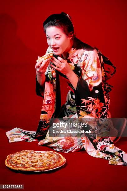 1980s Smiling Japanese Woman Wearing Traditional Kimono Eating Slice Of New York Style Pizza With Tomato Cheese SausAge Topping.