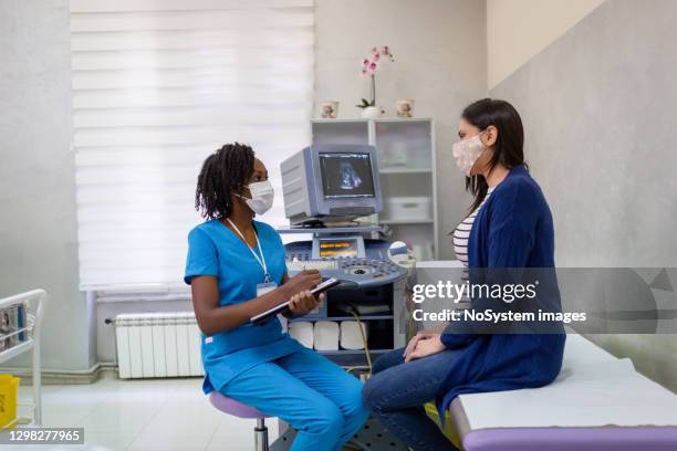 pregnant woman on gynecological examination - female doctor with mask stock pictures, royalty-free photos & images