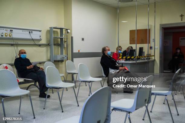 Elderly wear protective face masks and seat inside the observation room after being given a Pfizer/BioNTech COVID-19 jab at the Krakow University...