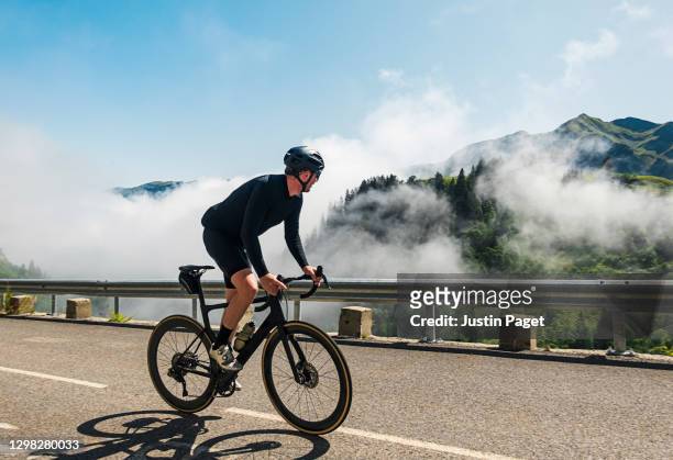 cyclist on the col de la colombiere in the french alps - roupa desportiva de protecção imagens e fotografias de stock