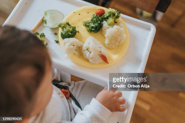 baby eating vegetables - portrait solid stock pictures, royalty-free photos & images