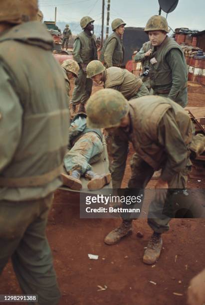 United States Marines bringing in an injured officer on a stretcher at a sandbag fort during the Vietnam War, in Hue, South Vietnam, 20th February...