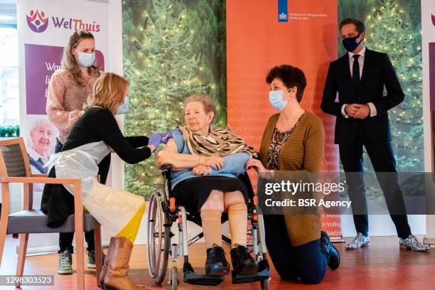 Minister of Health Hugo de Jonge is seen looking at an alderly woman who is receiving the Moderna COVID-19 vaccine during the kick off of the...