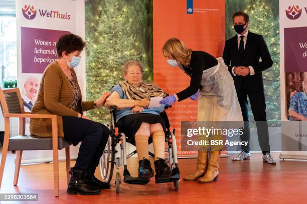 Minister of Health Hugo de Jonge is seen looking at an alderly woman who is receiving the Moderna COVID-19 vaccine during the kick off of the...