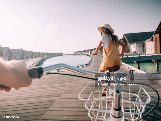 pov standpunkt des paares radfahren auf tropischer insel - luxury hotel island stock-fotos und bilder