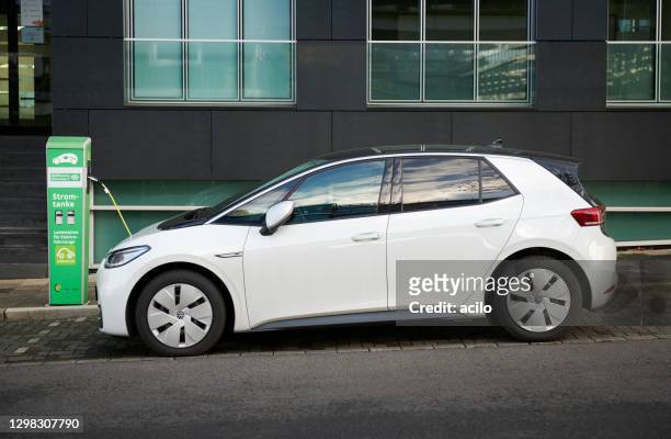 electric car / white volkswagen id 3 and recharging station - volkswagen stock pictures, royalty-free photos & images