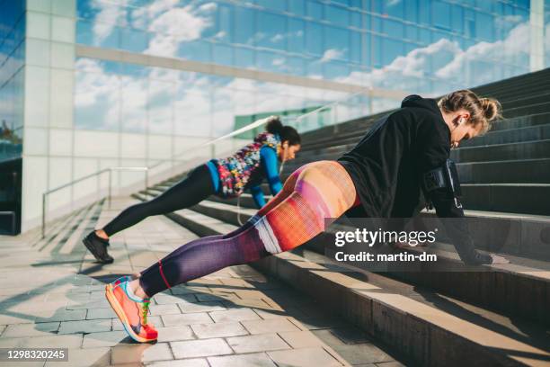 sportswomen exercising push-ups - center athlete stock pictures, royalty-free photos & images