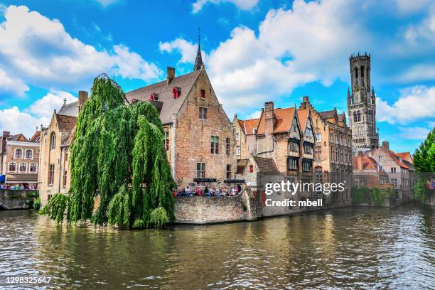 historical view of old bruges belgium and canals from rozenhoedkaai with view of belfry of bruges - brügge stock-fotos und bilder