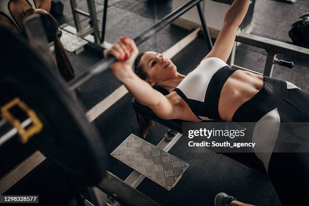 fit woman doing bench press exercise in gym - gym bench stock pictures, royalty-free photos & images