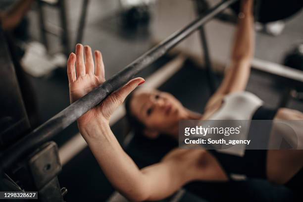 fit woman doing bench press exercise in gym - bench press stock pictures, royalty-free photos & images