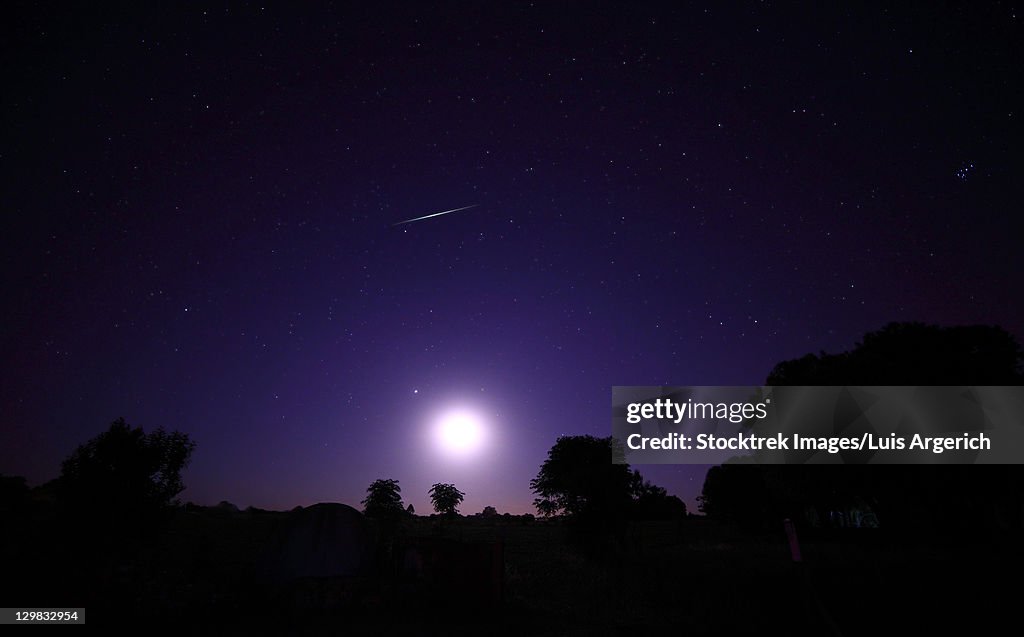 A bolide from the Geminids meteor shower above the setting moon in Mercedes, Argentina.