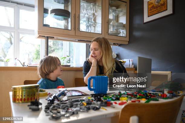 James Laurie, aged 8, is assisted in his online work by his mother Laurette as he continues home schooling, on January 25, 2021 in London, United...