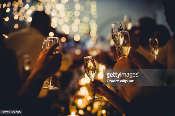 wedding celebratory toast with string lights and champagne silhouettes - wedding stock pictures, royalty-free photos & images