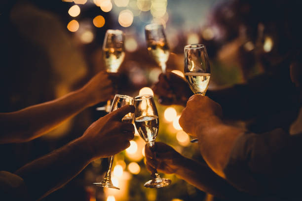 birthday celebratory toast with string lights and champagne silhouettes - christmas-party stock pictures, royalty-free photos & images