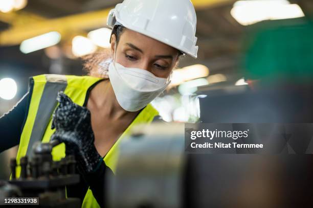 latin female worker operated manual lathe small machine in factory workshop. - atemschutz stock-fotos und bilder